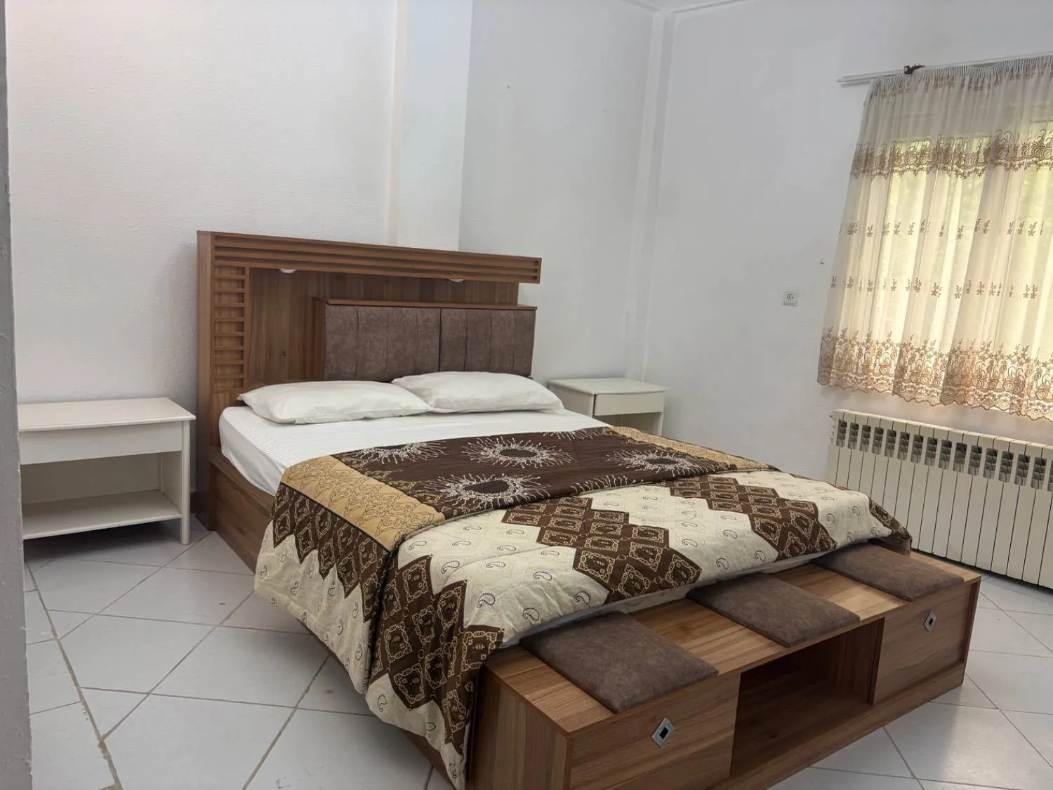 تخت دونفره با روتختی طرح‌دار در هتل فاندر