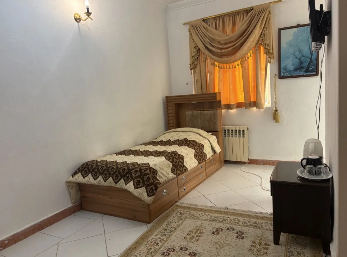 تخت یک‌نفره با روتختی طرح‌دار در هتل فاندر