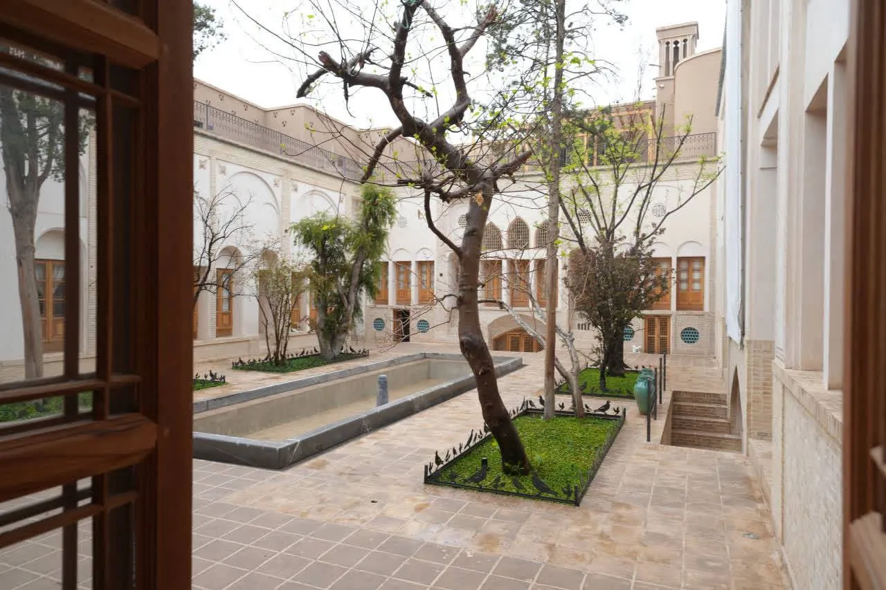 حیاط تاریخی استادی با حوض و درختان