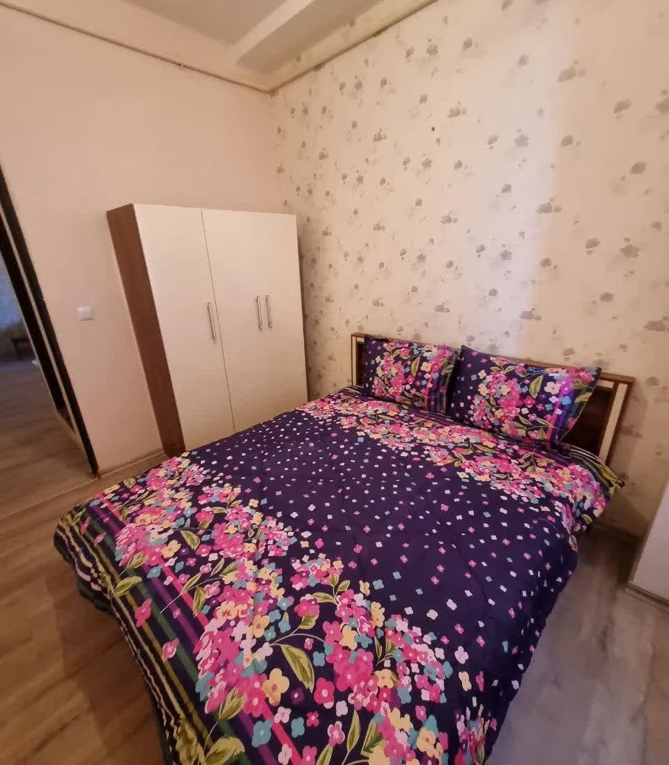 تخت دونفره با روتختی گل‌دار در طاق بستان
