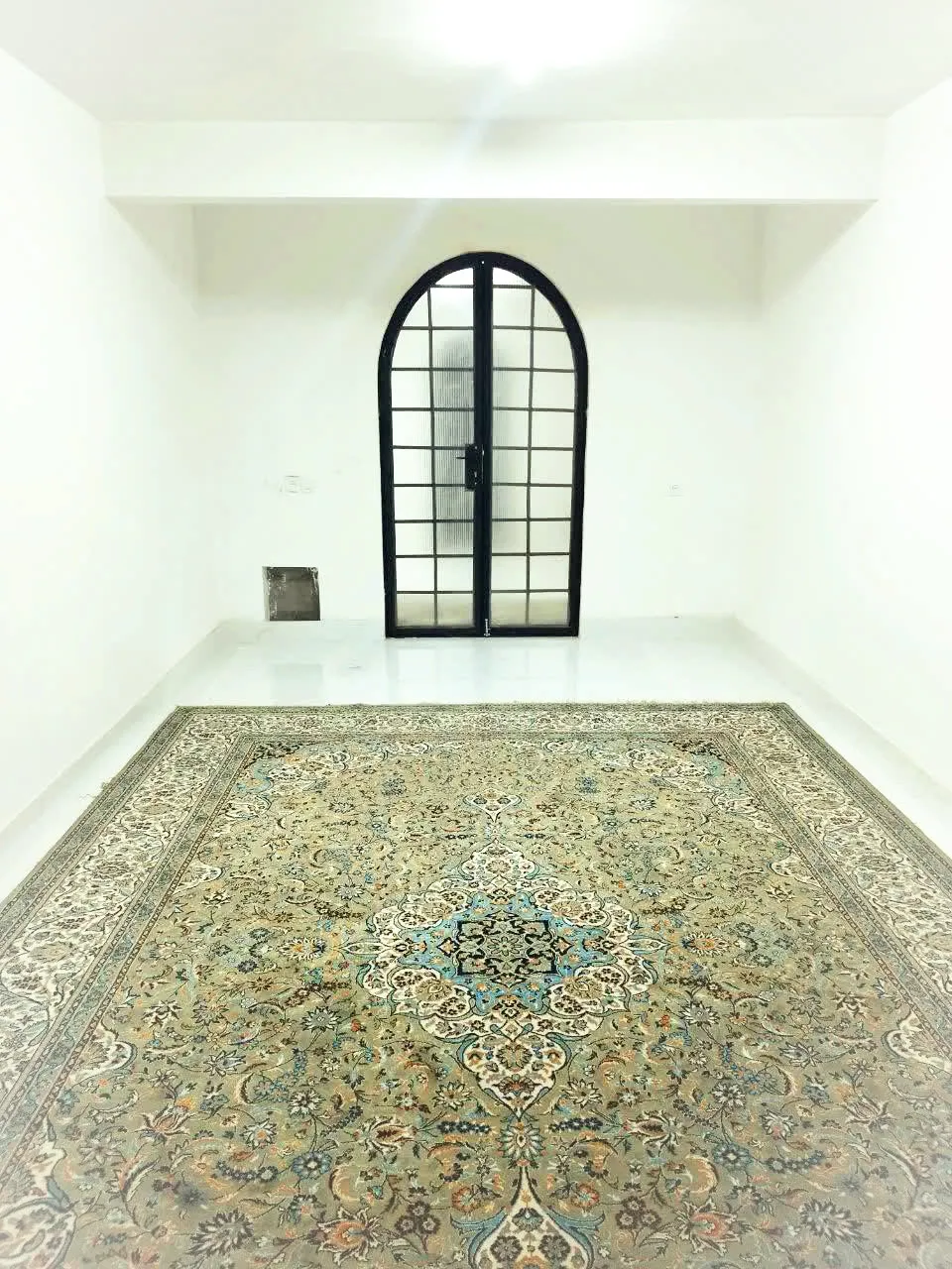 اتاق خالی تنگ بهرام با فرش و در قوسی