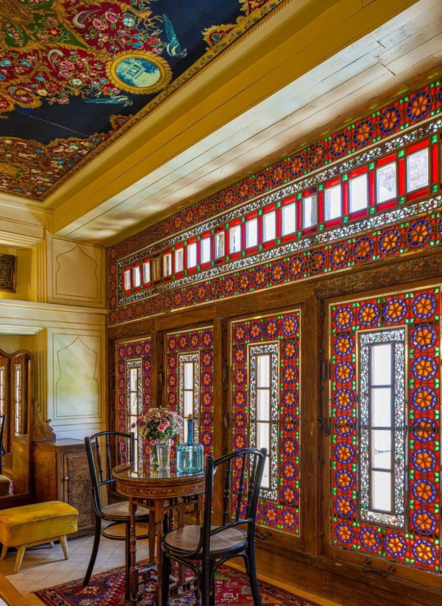 اتاق خانه شیرازی با پنجرههای رنگی و میز چوبی
