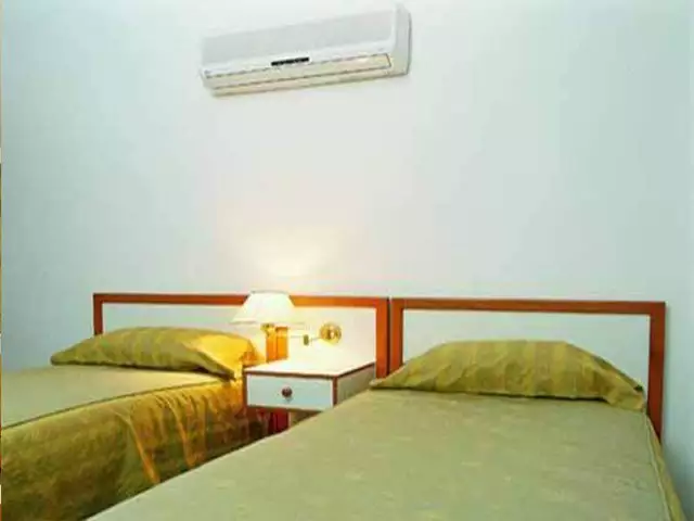 دو تخت یک‌نفره با پاتختی در هتل آریان
