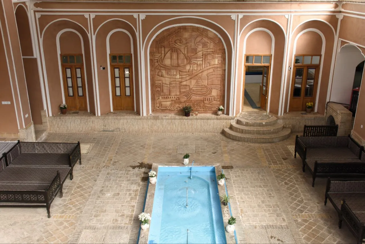 حیاط سنتی هتل سنتی گلشن با حوض و نقوش آجری