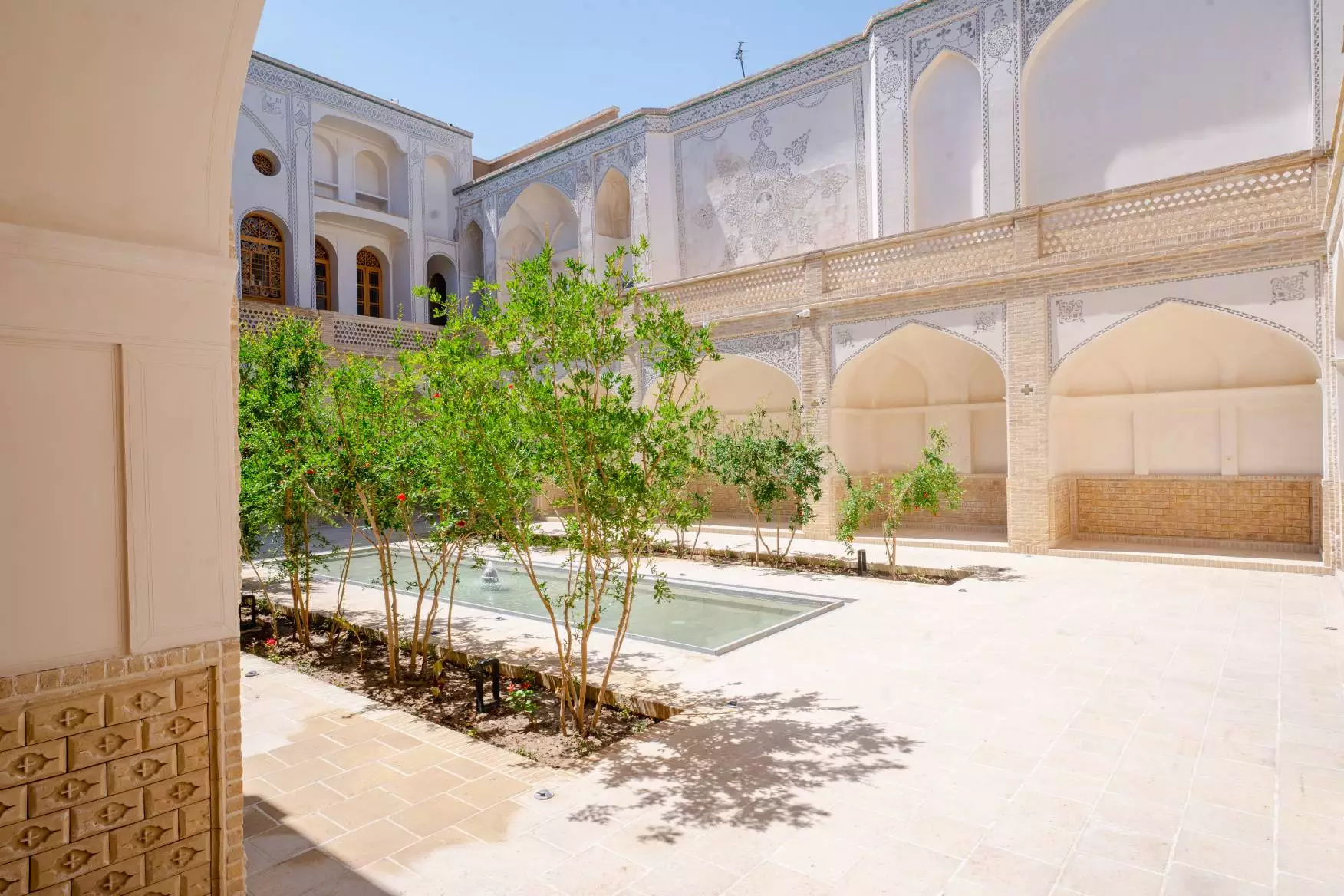 حیاط خانه لاجوردی با حوض و درختان