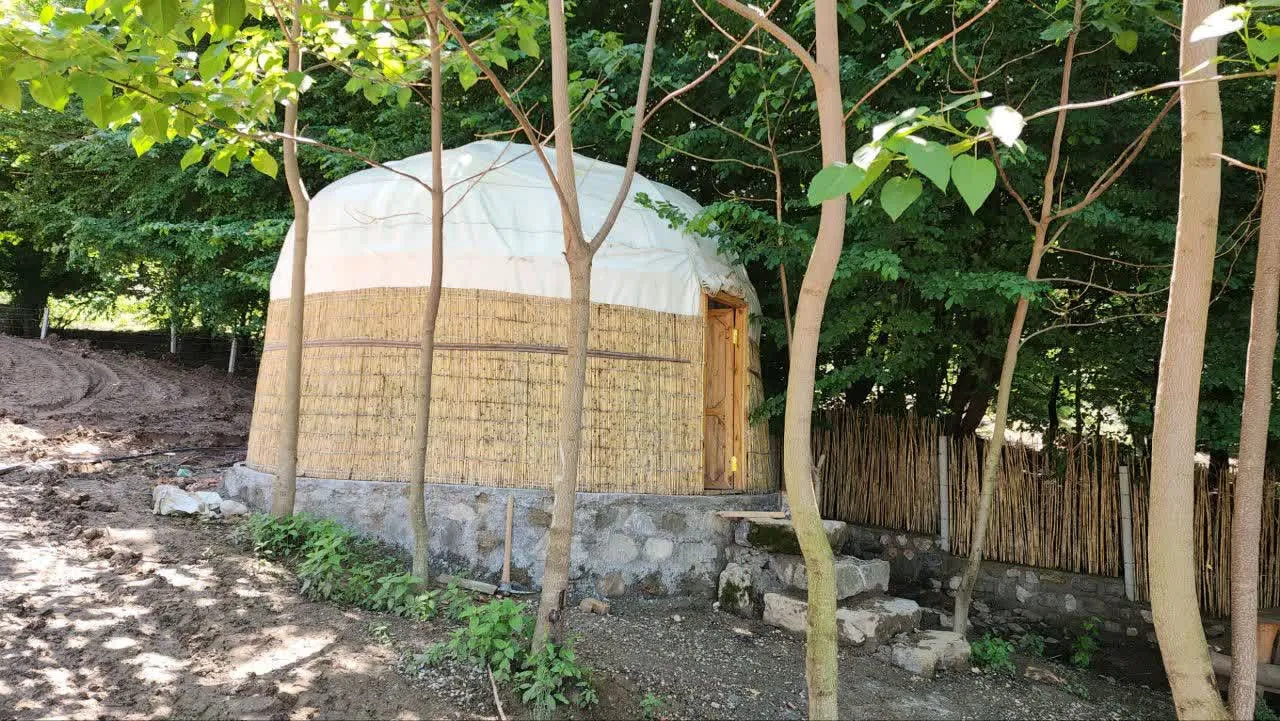 کلبه حصیری گرد در میان درختان اقامتگاه پرهام