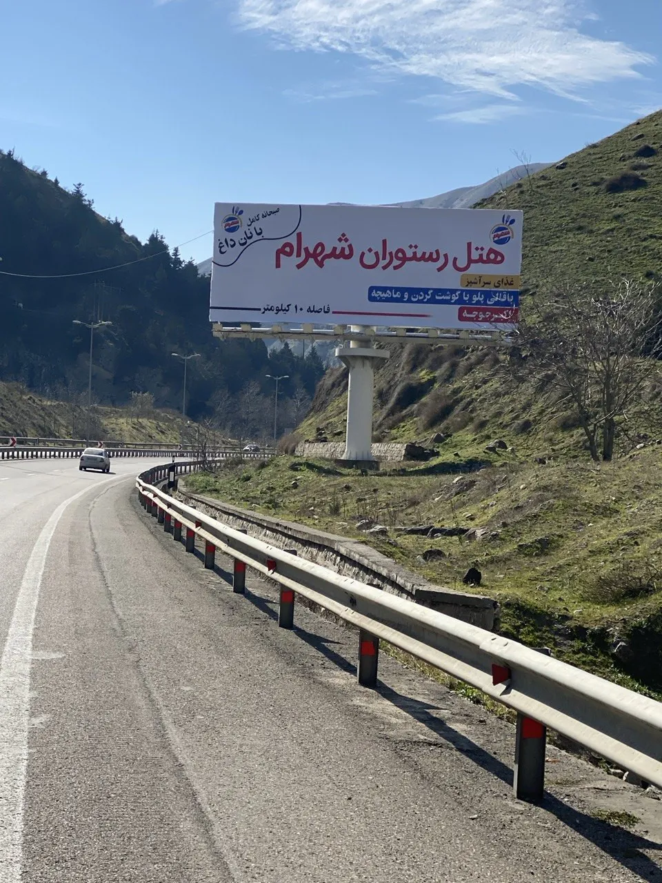 تابلوی هتل رستوران شهرام کنار جاده کوهستانی