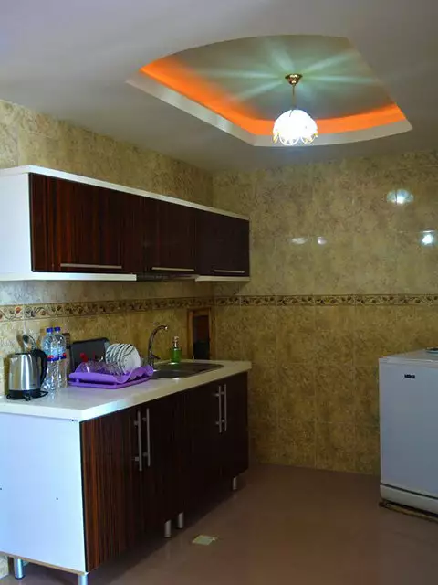 آشپزخانه هتل ماهان با کابینت تیره و یخچال