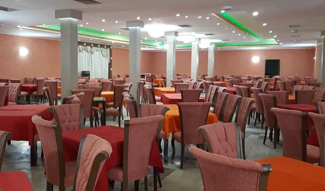 صندلی‌های صورتی و میزهای سالن غذاخوری هتل استقلال