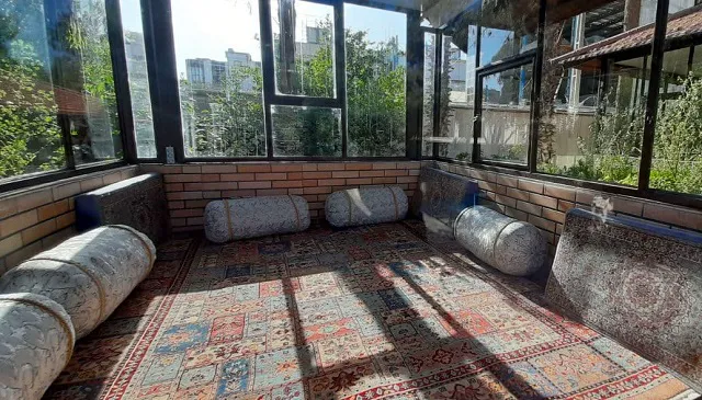 نشیمن شیشه‌ای هتل استقلال با فرش و پشتی