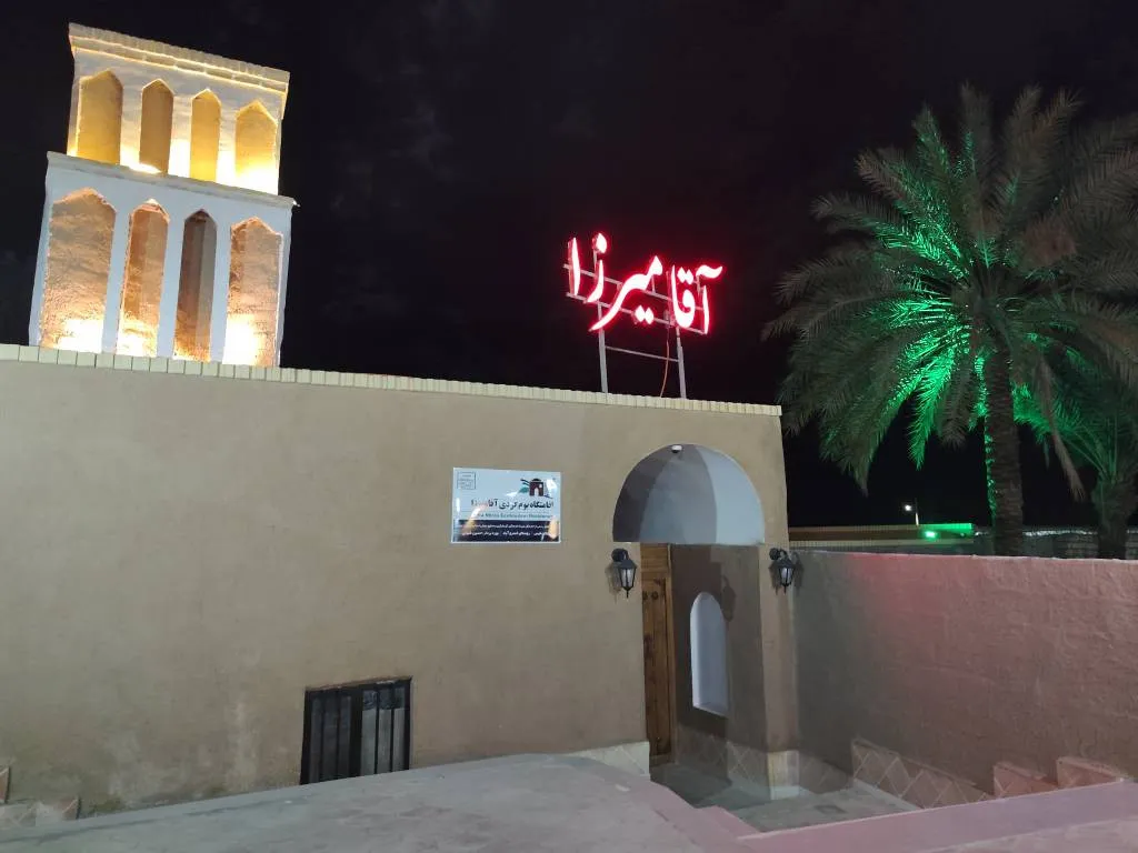 ورودی هتل آقامیرزا با سردر روشن و نخل در شب