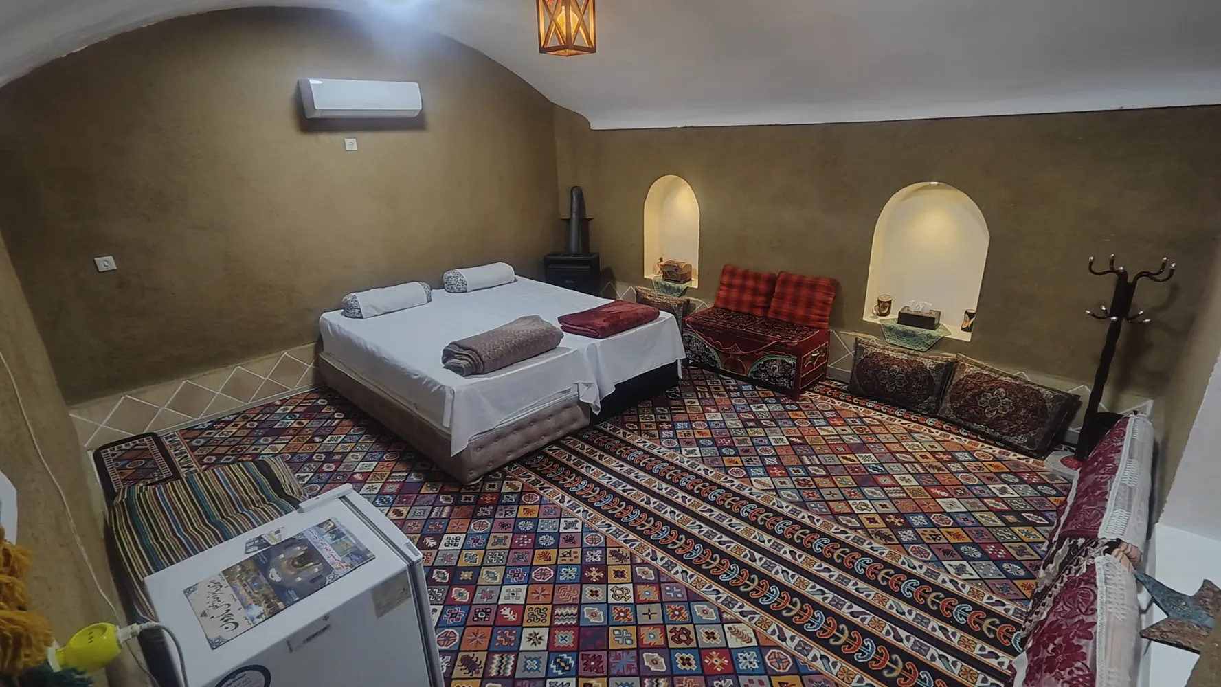 اتاق اقامتگاه آقامیرزا با تخت و فرش رنگارنگ