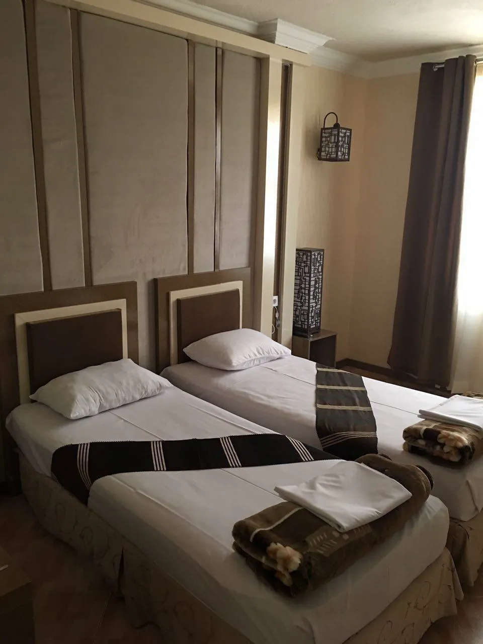 دو تخت یک‌نفره با روتختی تیره در پارسه
