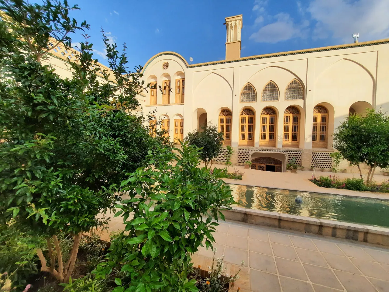 حیاط سنتی هتل اشکوب با حوض و درختان
