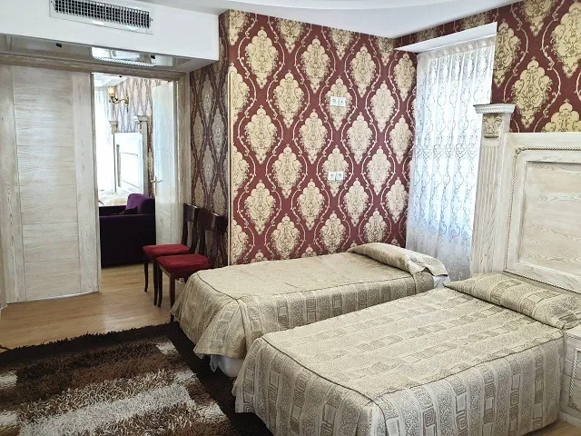 دو تخت یک‌نفره در اتاق هتل صادقیه توس
