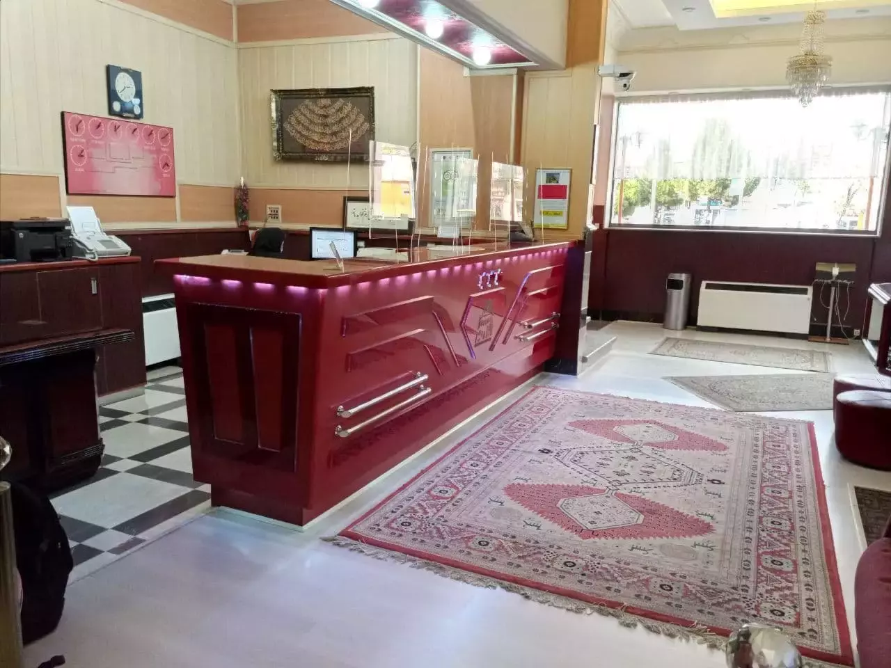 پذیرش هتل پارک با پیشخوان قرمز و فرش ایرانی