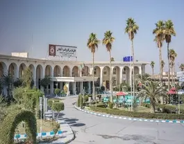 نمای بیرونی هتل پارس کاروانسرا با نخل و محوطه سبز