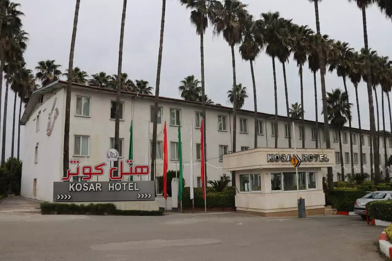 ساختمان هتل کوثر و سردر ورودی میان نخل‌ها