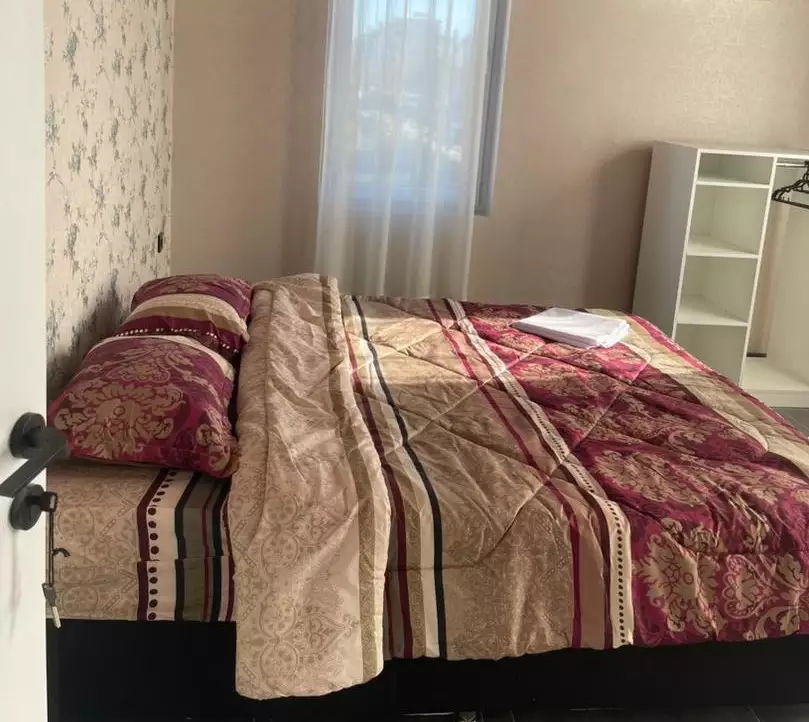 تخت دونفره اتاق هتل امیران با روتختی طرح‌دار