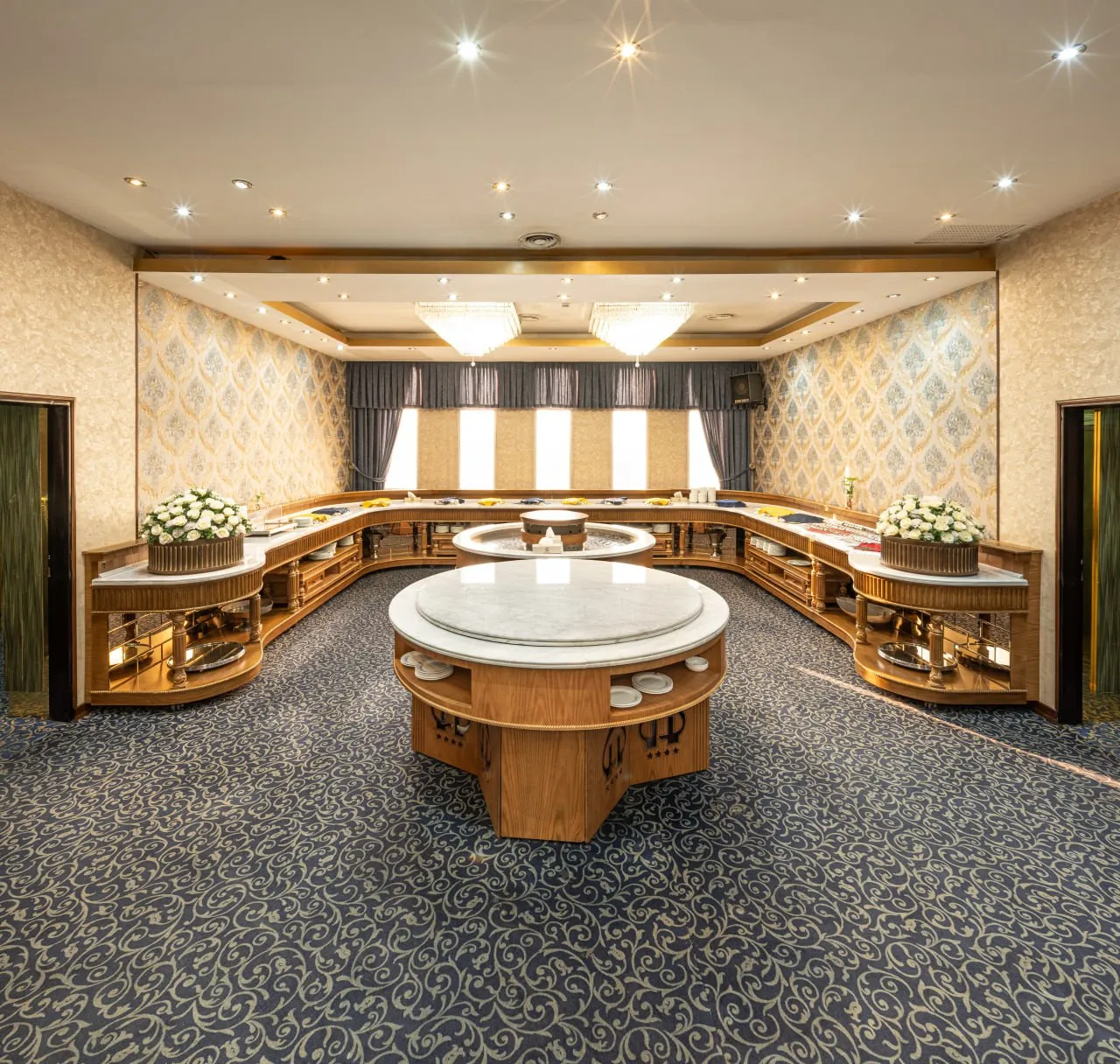 فضای پذیرایی هتل بزرگ پارسیا با میزهای چوبی و مرکزی