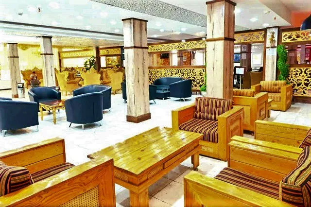 مبلمان چوبی و صندلی‌های راه‌راه در لابی هتل شهریار