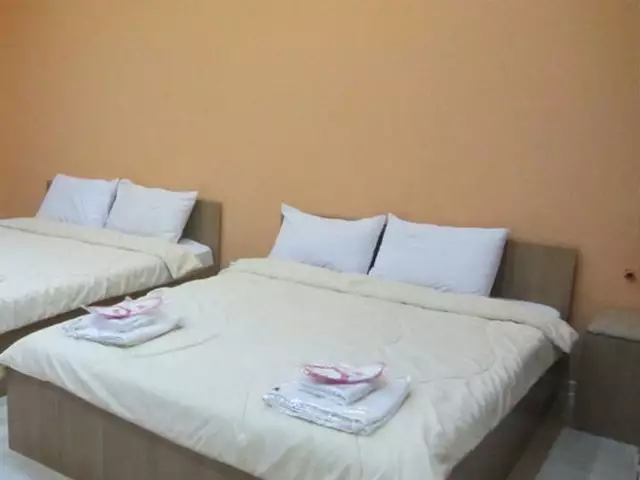 دو تخت دونفره با ملحفه سفید در خانه رز