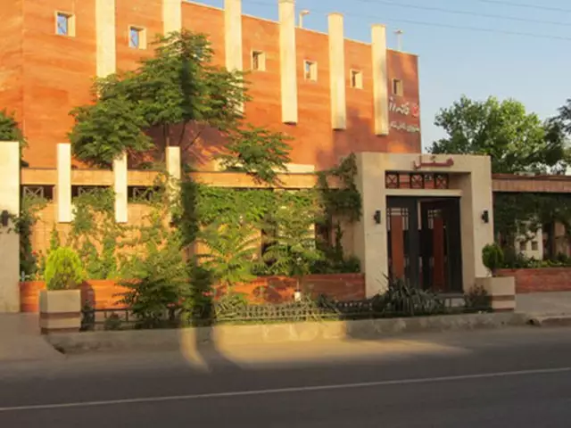 نمای بیرونی هتل خانه رز با نمای آجری و فضای سبز