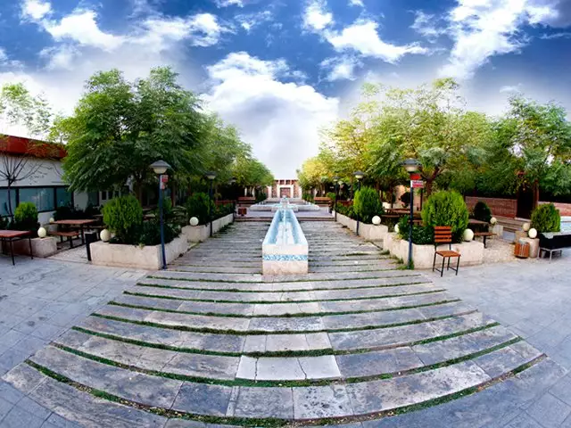 حیاط نگین با آب‌نمای مرکزی و درختان سرسبز