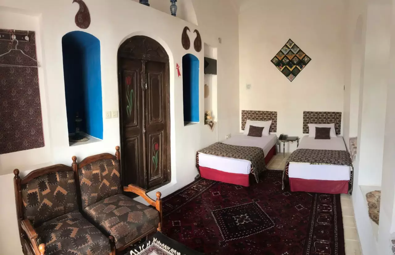 اتاق دو تخته هتل نگین با تختهای جداگانه و نشیمن سنتی