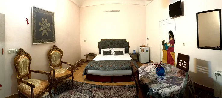 اتاق هتل نگین با تخت دونفره و صندلیهای سنتی