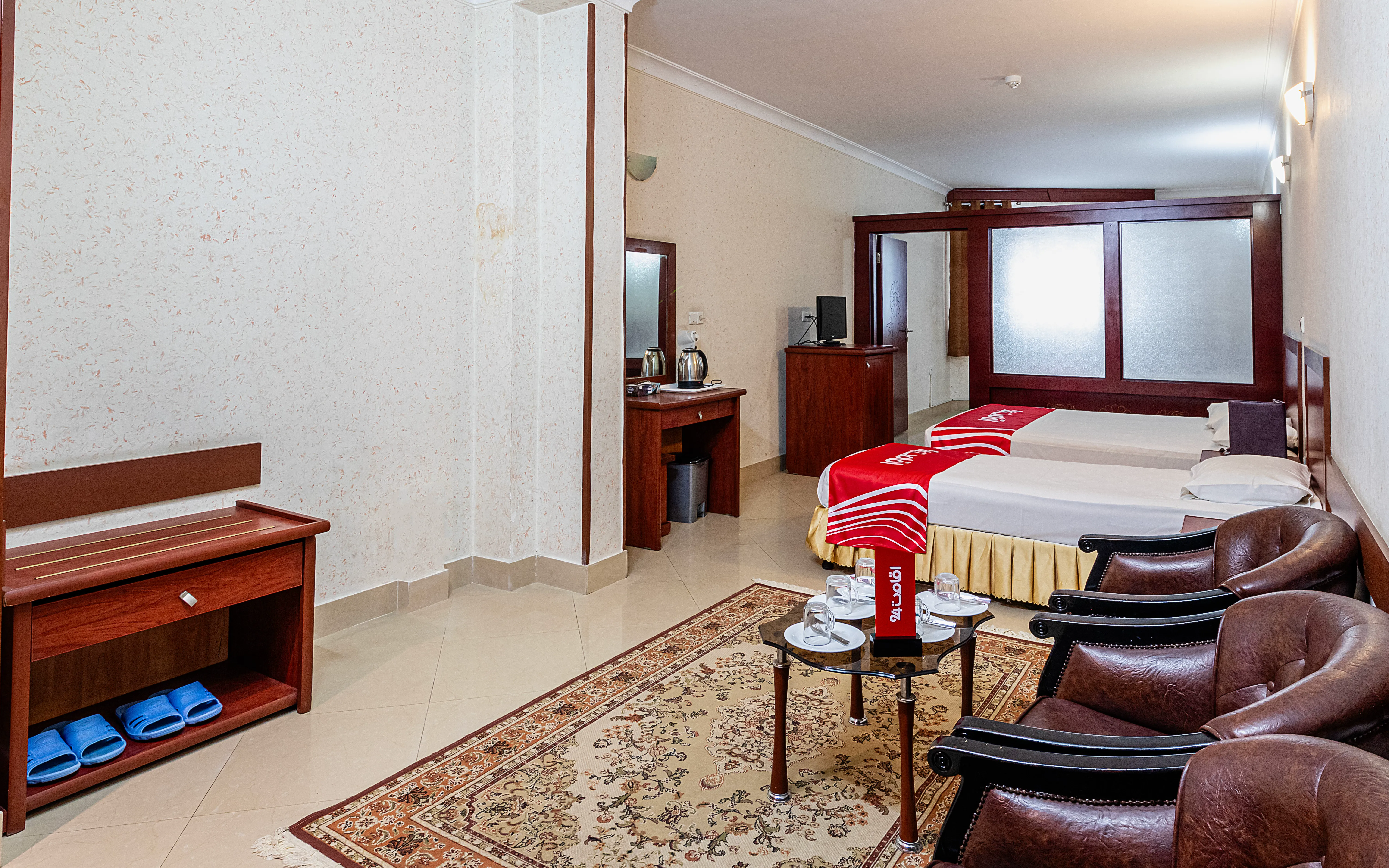 اتاق هتل هلیا با تختهای دونفره و نشیمن