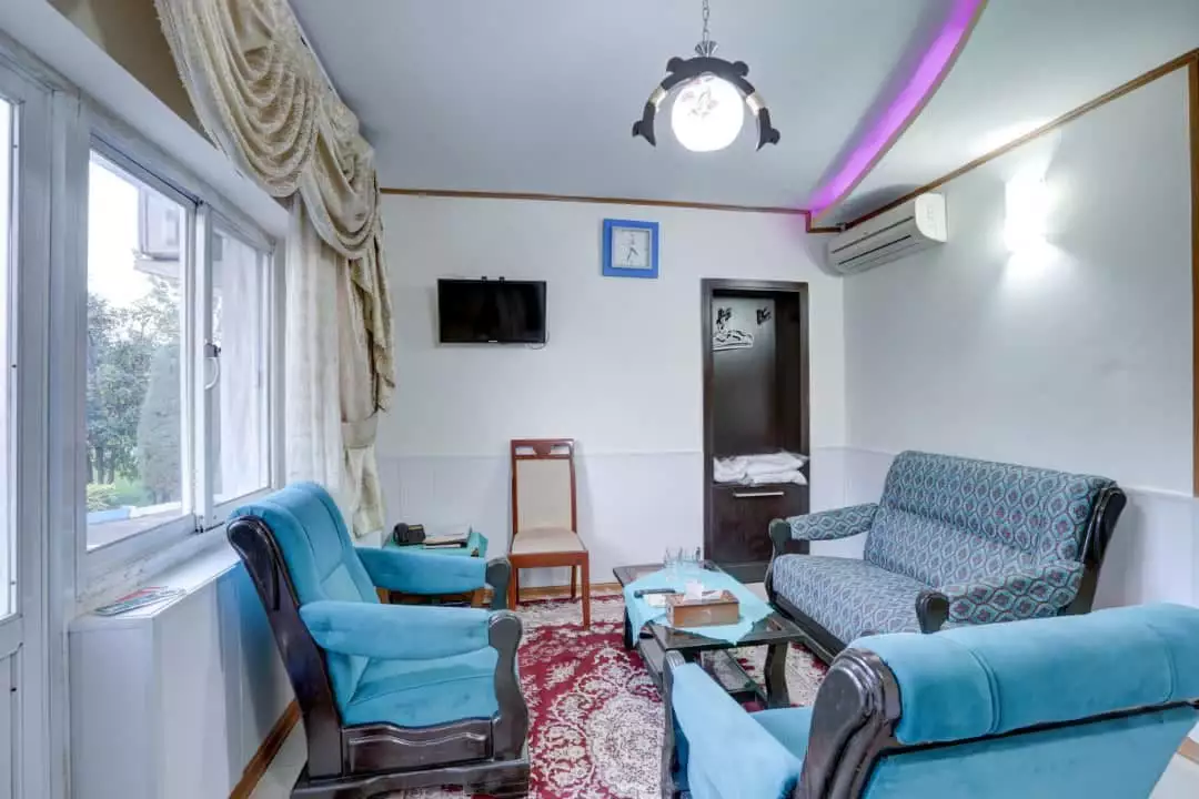 مبلمان آبی و فرش قرمز نشیمن هتل جهانگردی