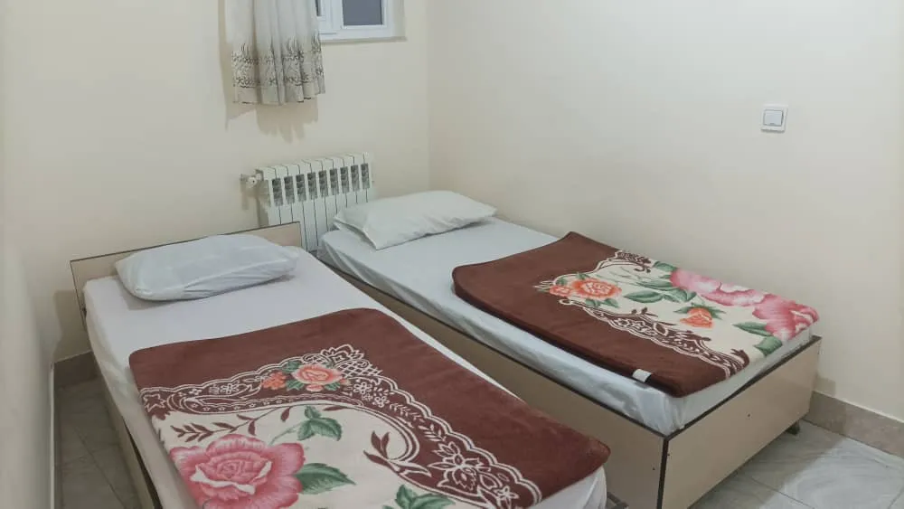 دو تخت یکنفره با روتختی گلدار در هتل صدرا