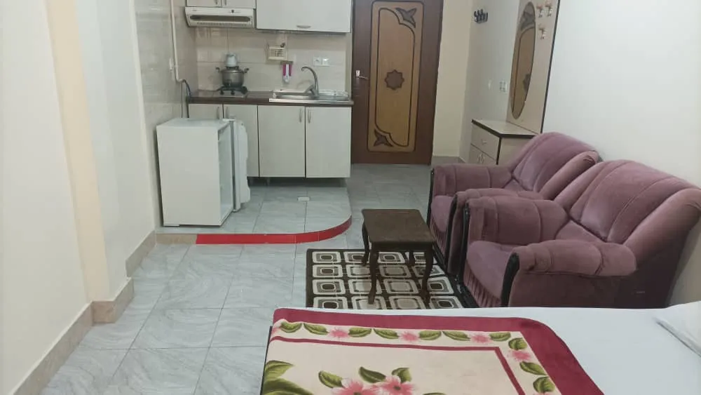 اتاق هتل صدرا با تخت، نشیمن و آشپزخانه کوچک