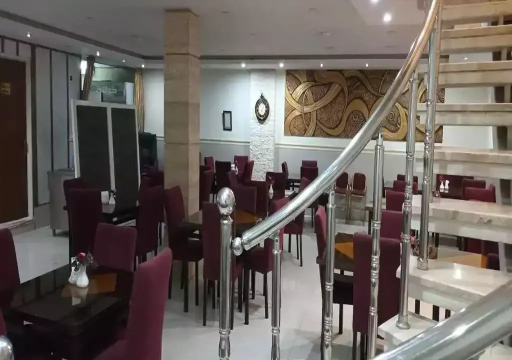 سالن غذاخوری معین درباری با صندلی‌های زرشکی