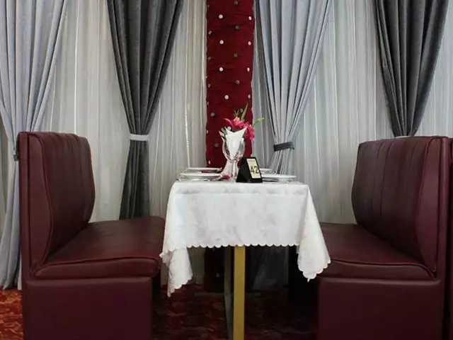 میز دونفره با گلدان گل در هتل رنگین کمان
