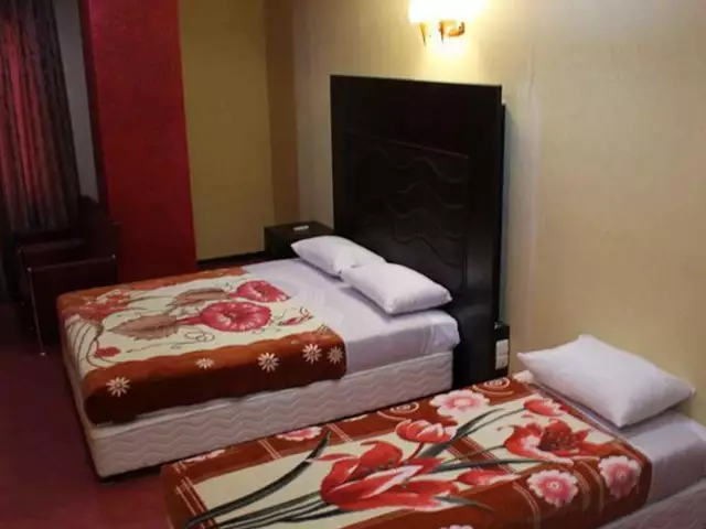 دو تخت با روتختی گل‌دار در هتل رنگین کمان