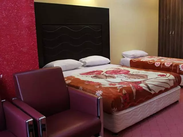 تخت دونفره با روتختی گل‌دار در هتل رنگین کمان