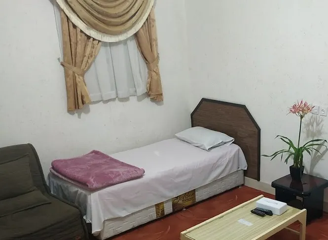 تخت یک‌نفره کنار پنجره و مبل در هتل فدک