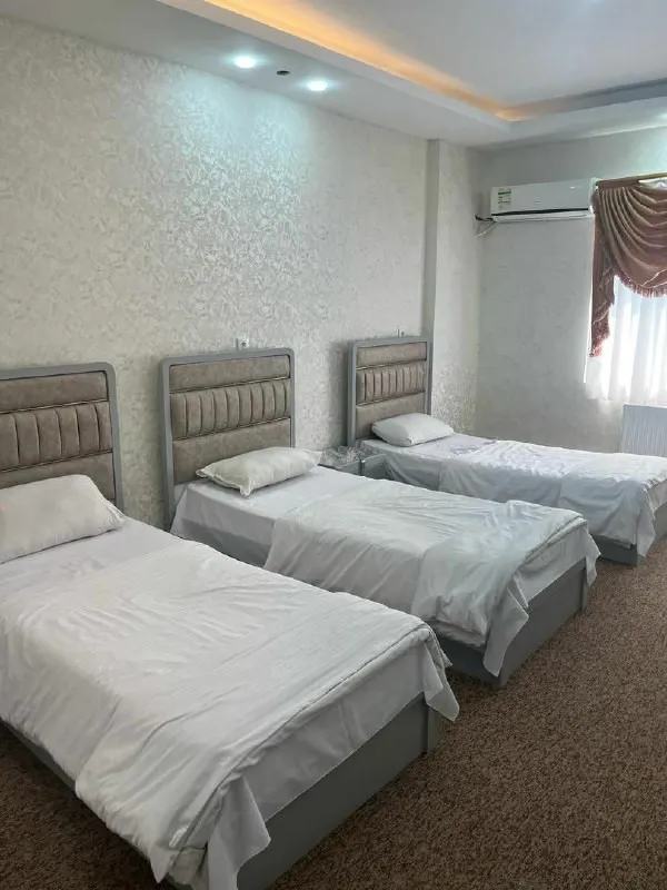 سه تخت یکنفره در اتاق هتل کهکشان