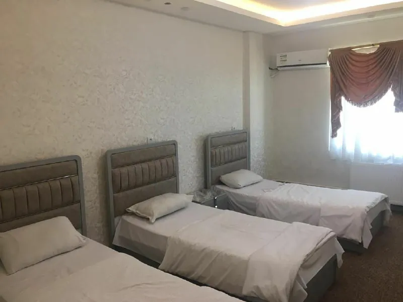 سه تخت یکنفره در اتاق هتل کهکشان