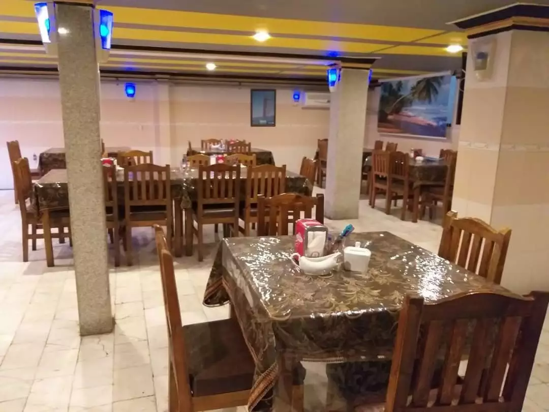 رستوران هتل قابوس با میز و صندلی چوبی