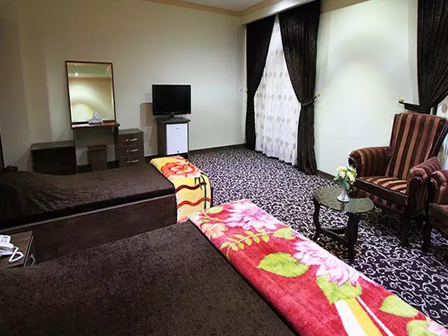 اتاق هتل امام رضا با تخت و مبلمان نشیمن