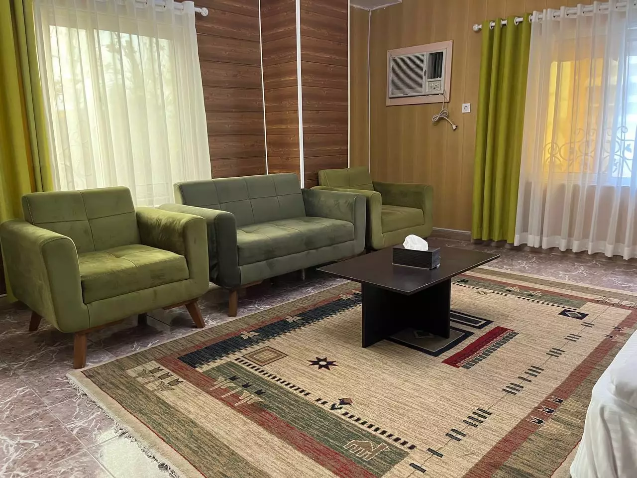 کوشال، نشیمن با مبل‌های سبز و فرش طرح‌دار
