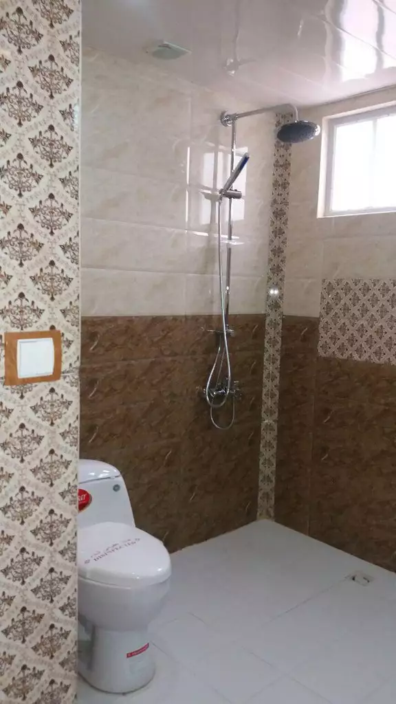 حمام جهانگردی با دوش و کاشی‌کاری طرح‌دار