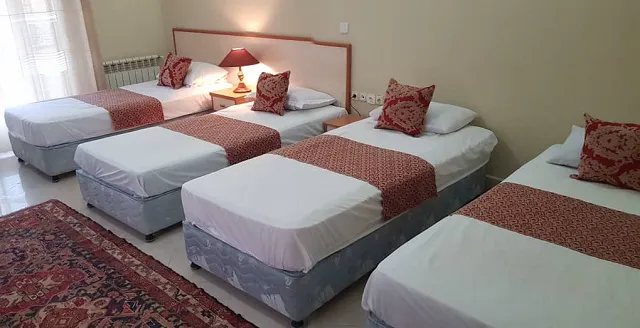 چند تخت یک‌نفره با روتختی سنتی در هتل ابیانه