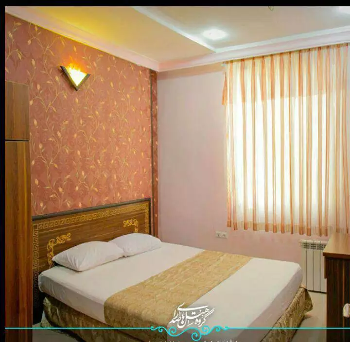 تخت دونفره اتاق هتل ایوان کنار پنجره پرده‌دار