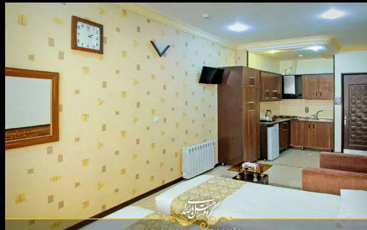 نمای اتاق هتل ایوان با تخت و آشپزخانه کوچک