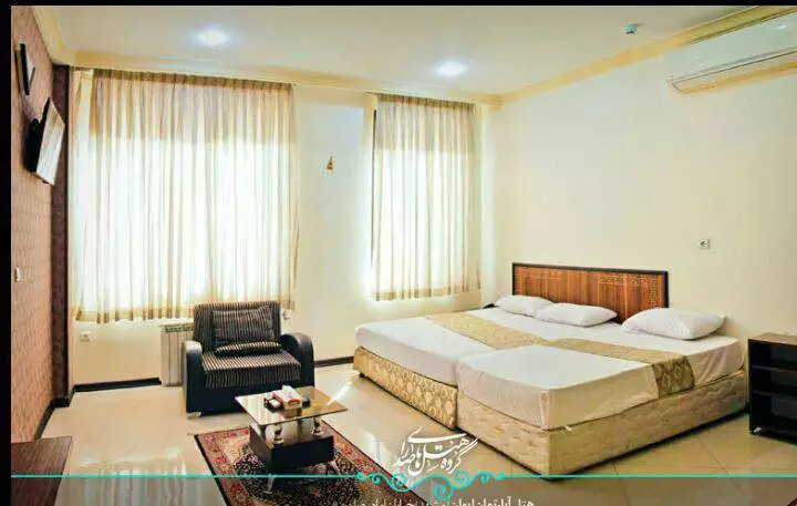 اتاق هتل ایوان با تخت دونفره و پنجره‌های قدی