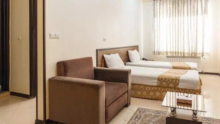 اتاق هتل ایوان با دو تخت و مبل راحتی